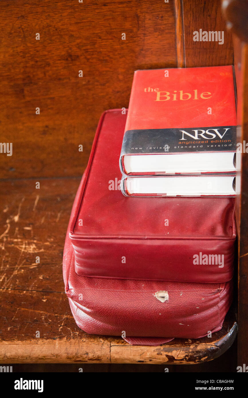Bible and kneeling cushion on church pew Stock Photo Alamy