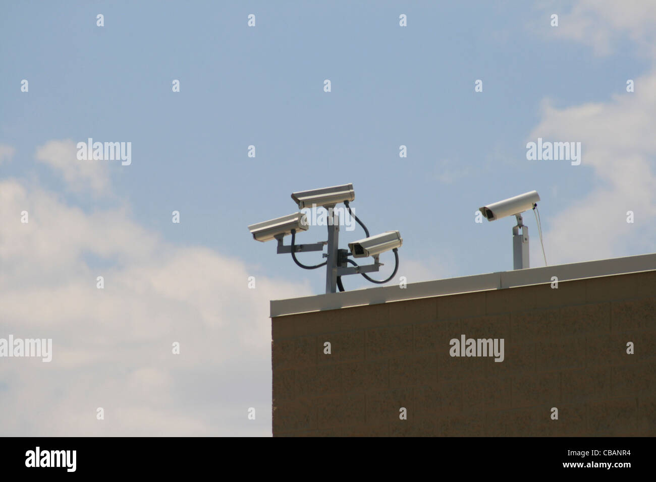 multiple security cameras record from the corner of a building Stock Photo
