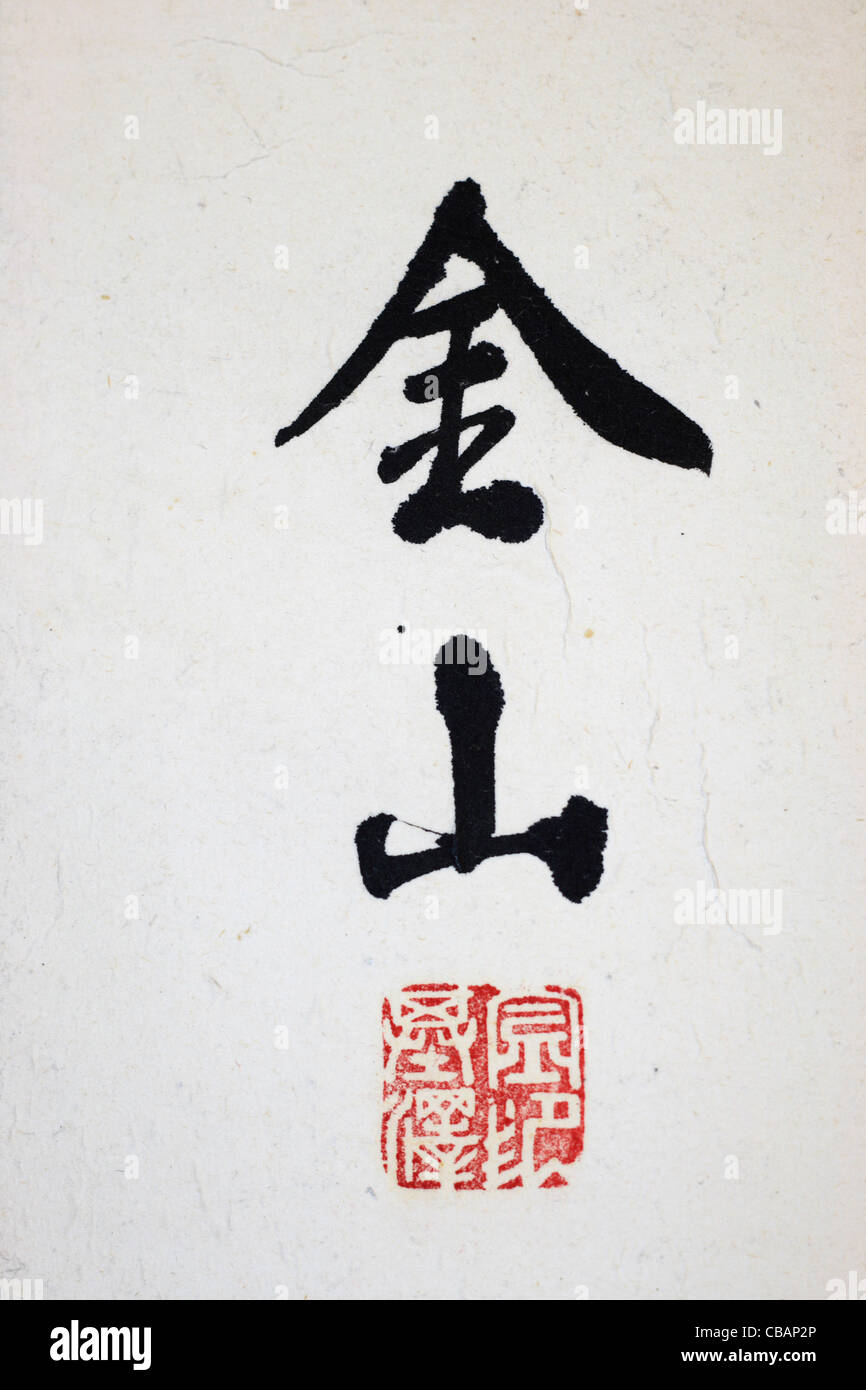 black Asian calligraphy for gold and mountain on white paper with red stamp Stock Photo