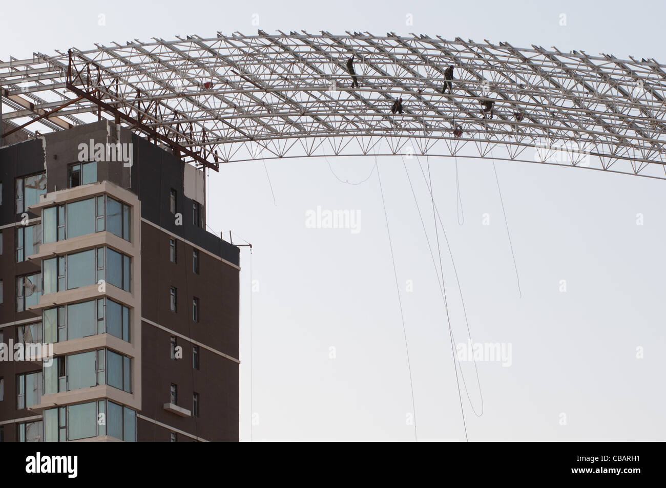 Workers on the roof of a building under construction. Dezhou, Shandong, China Stock Photo