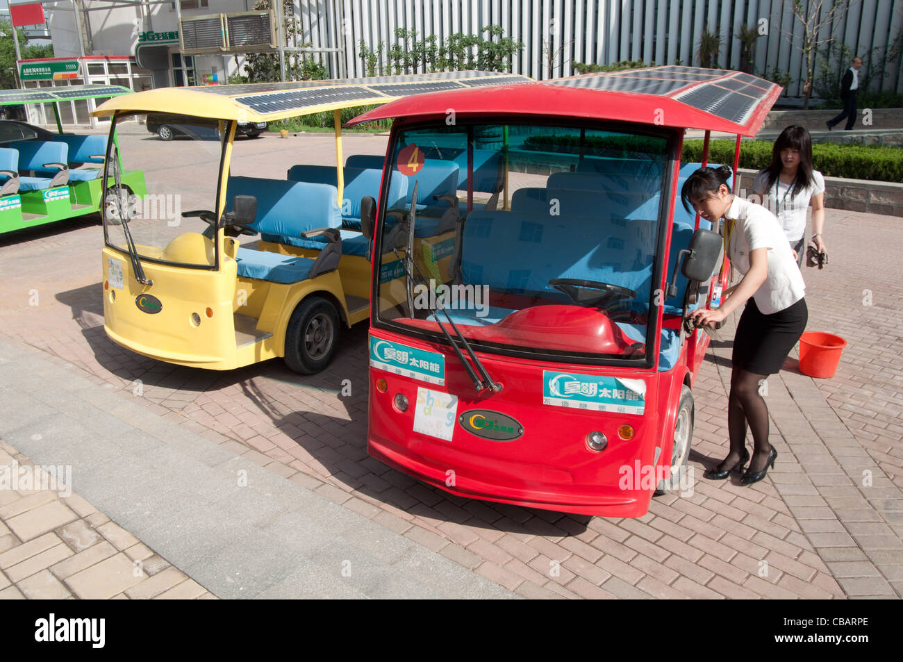 Two hostess set up a solar powered bus. China Solar Valley, Dezhou, Shandong, China Stock Photo