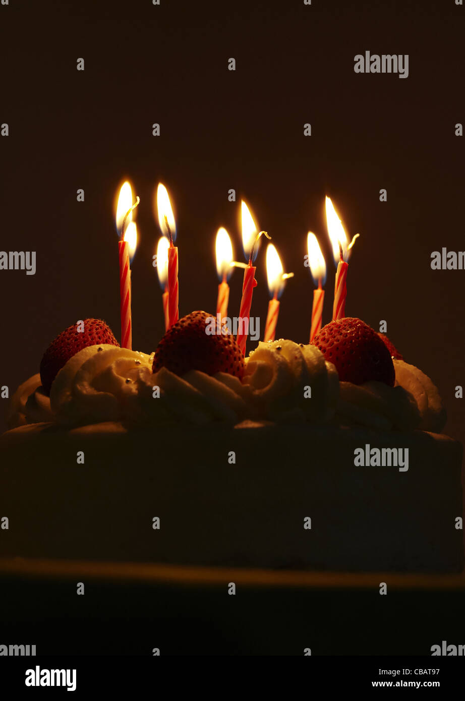 Strawberry birthday cake with lit candles Stock Photo - Alamy