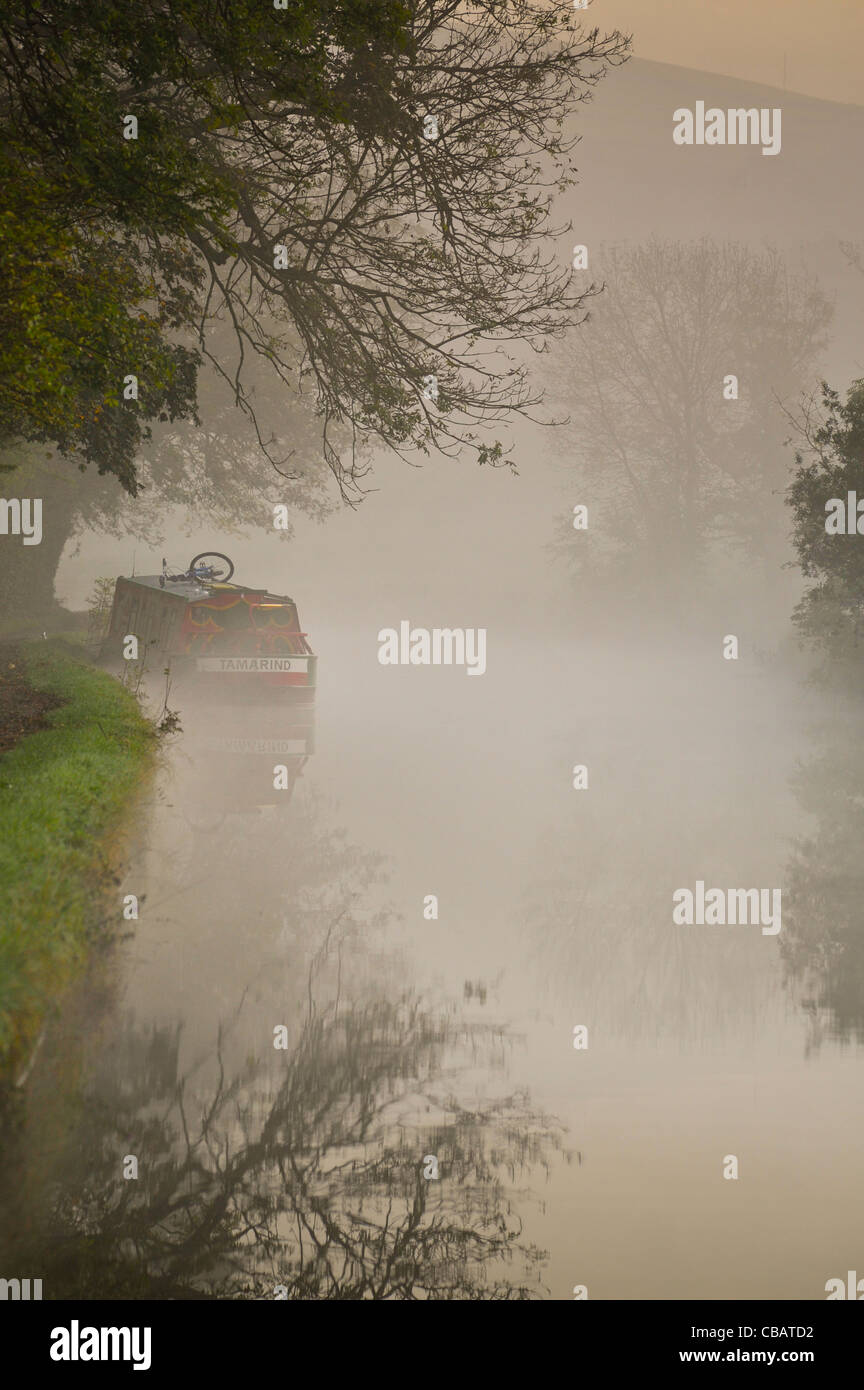 A narrowboat in the morning mist on the Leeds Liverpool Canal near Skipton, Yorkshire, UK. Stock Photo