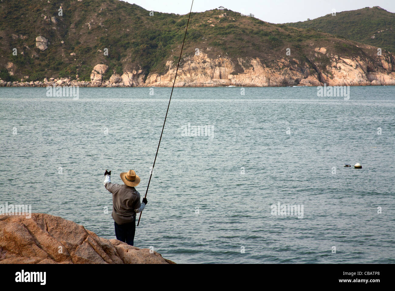 Man fishing on the rocks by Tung Wan Beach, Cheung Chau, Hong Kong ...