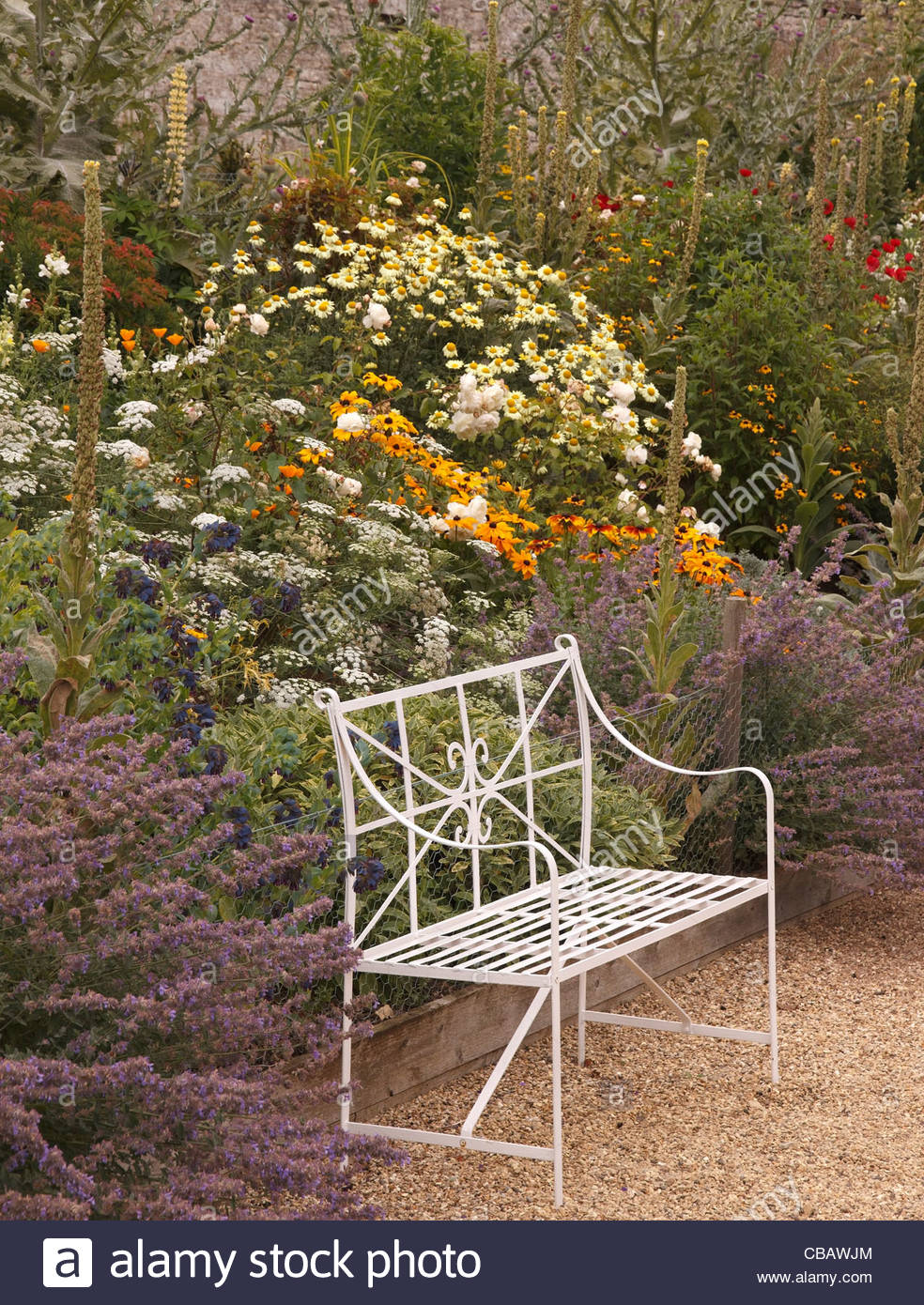 Ornate White Metal Bench Seat In Front Of Flower Bed Border At