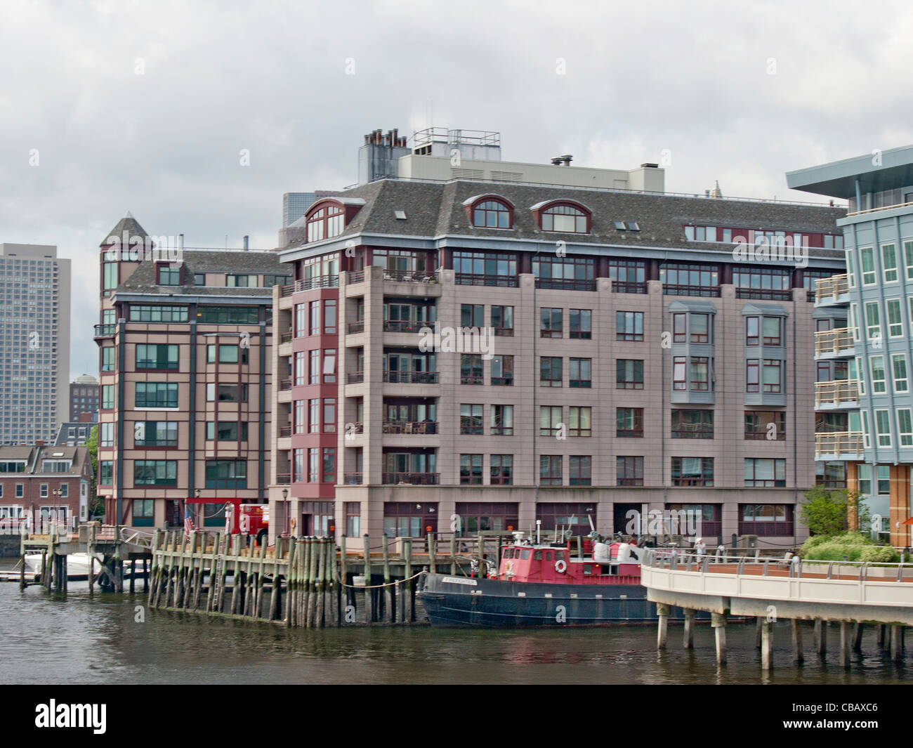 Luxury condos on Boston Harbor pier with docked fire boat Stock Photo Alamy