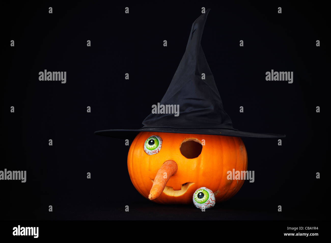 Halloween lantern in the shape of a witches face with one eye missing against a black background Stock Photo