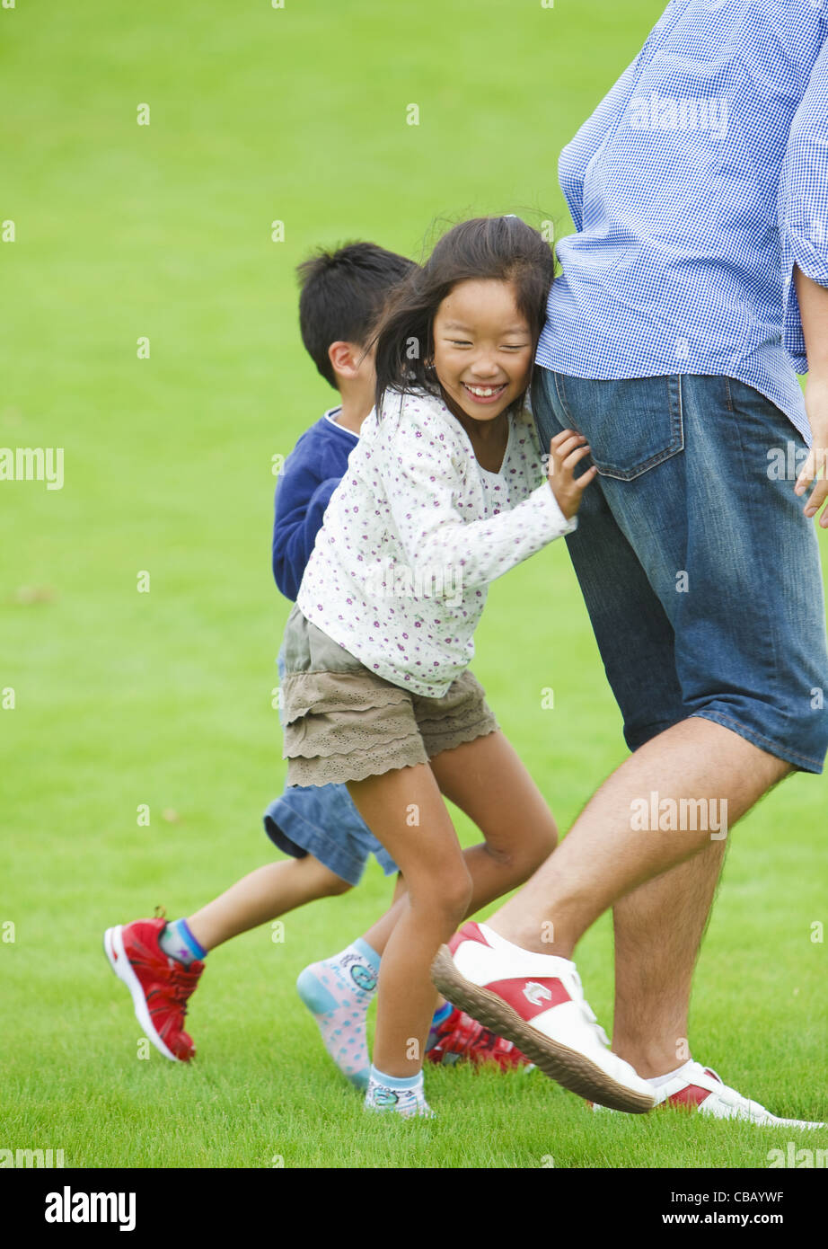 Father and children playing on grass Stock Photo