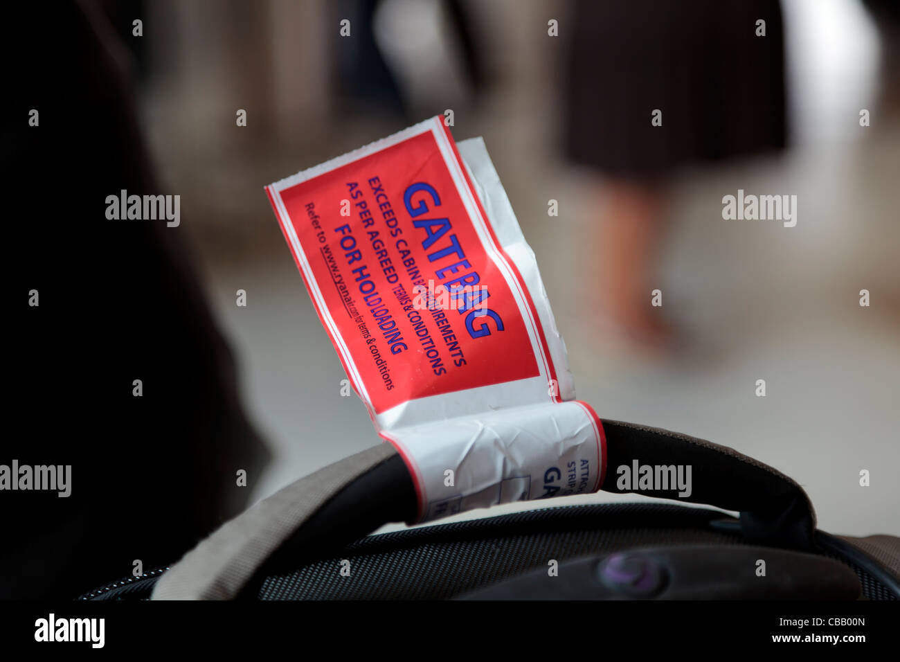 Label on luggage at airport fitted at gate to send oversize or overweight hand luggage for hold loading. Stock Photo