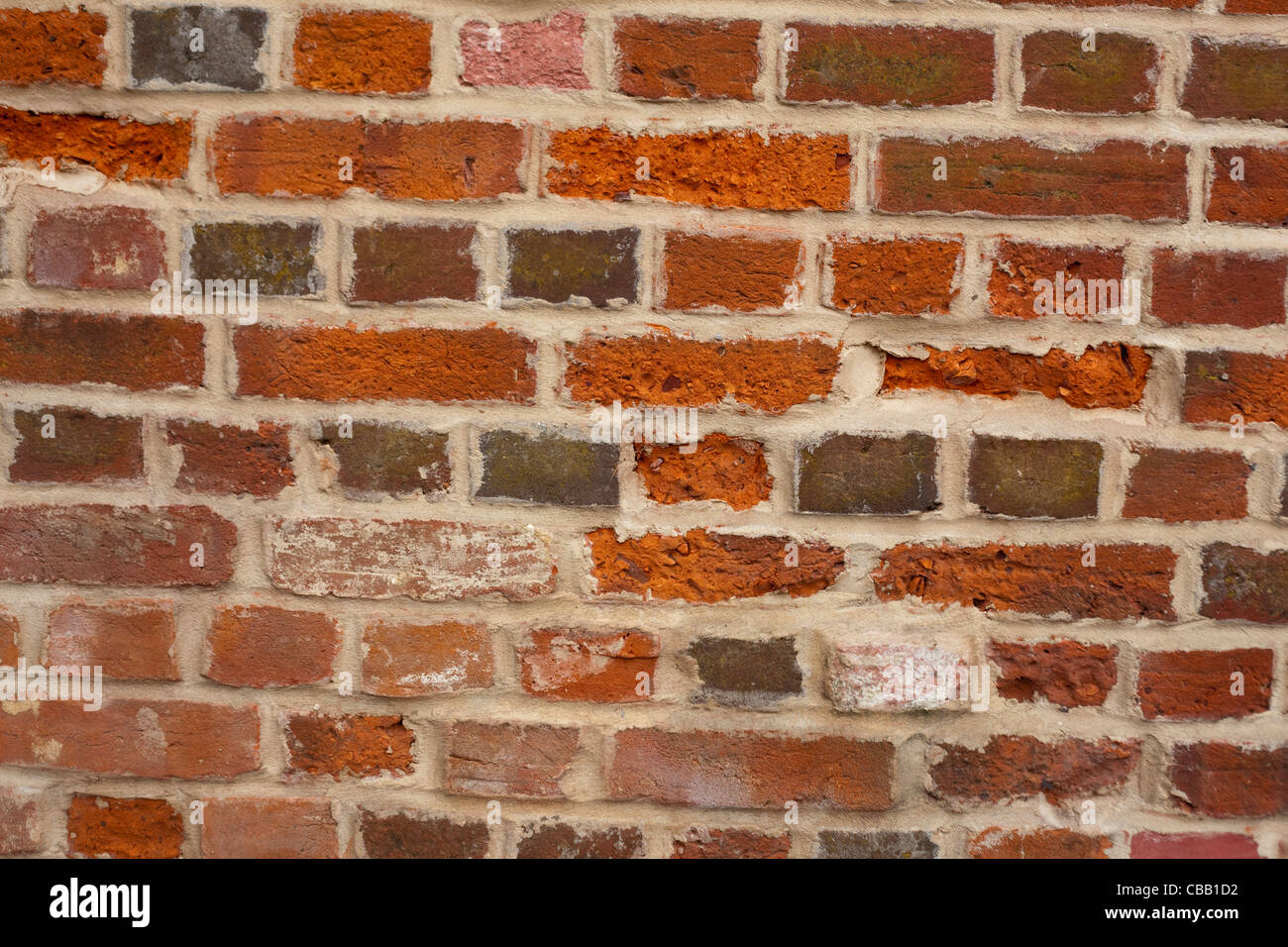 Old Brick Wall constructed from locally fired clay. Aylsham, Norfolk. Re-pointed with cement. Stock Photo