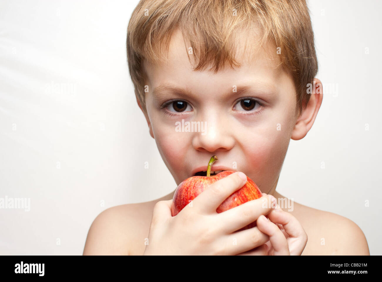 Boy eating a red gala apple Stock Photo Alamy
