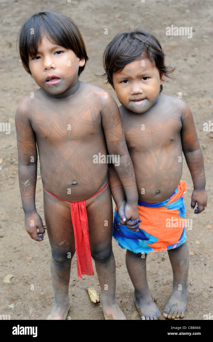 Embera indian brothers in red loincloth and skirt hand in hand at the Embera Puru indigenous community, Panama Stock Photo