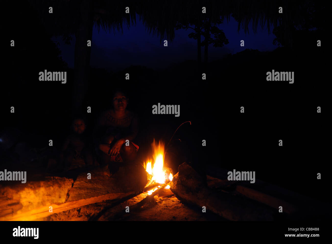 Embera Indian mother and son behind a bonfire in the jungle during the nightfall at the Embera Puru community in Panama Stock Photo