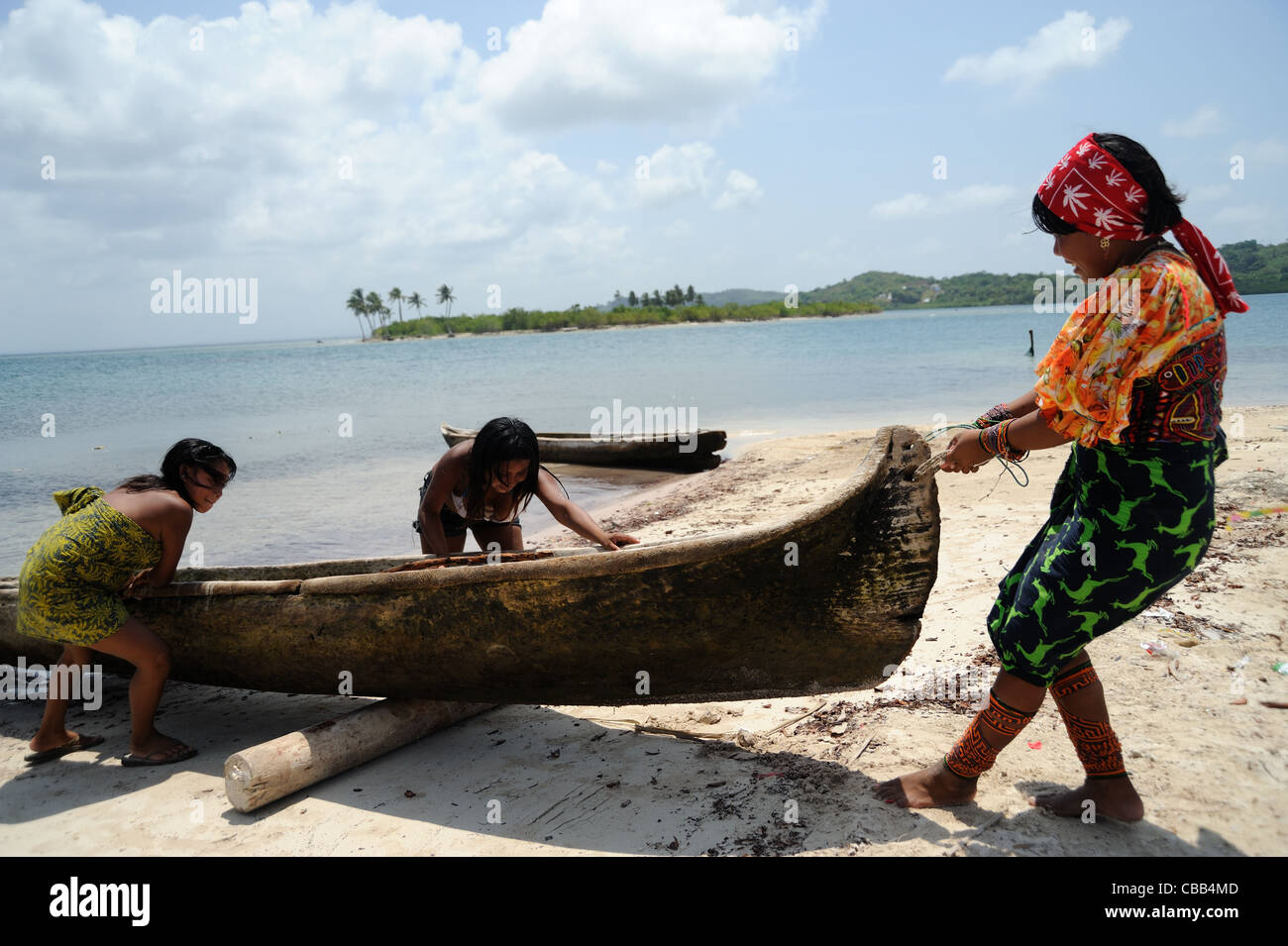 Guna indigenous woman with kids beaching a cayuco at Corbisky island in Guna Yala, Panama. Stock Photo