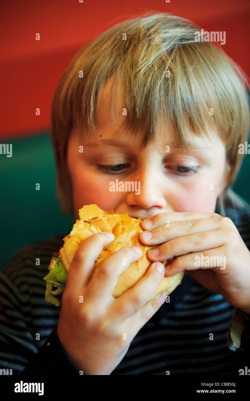 Stock photo of an 11 year old boy eating a burger Stock Photo Alamy