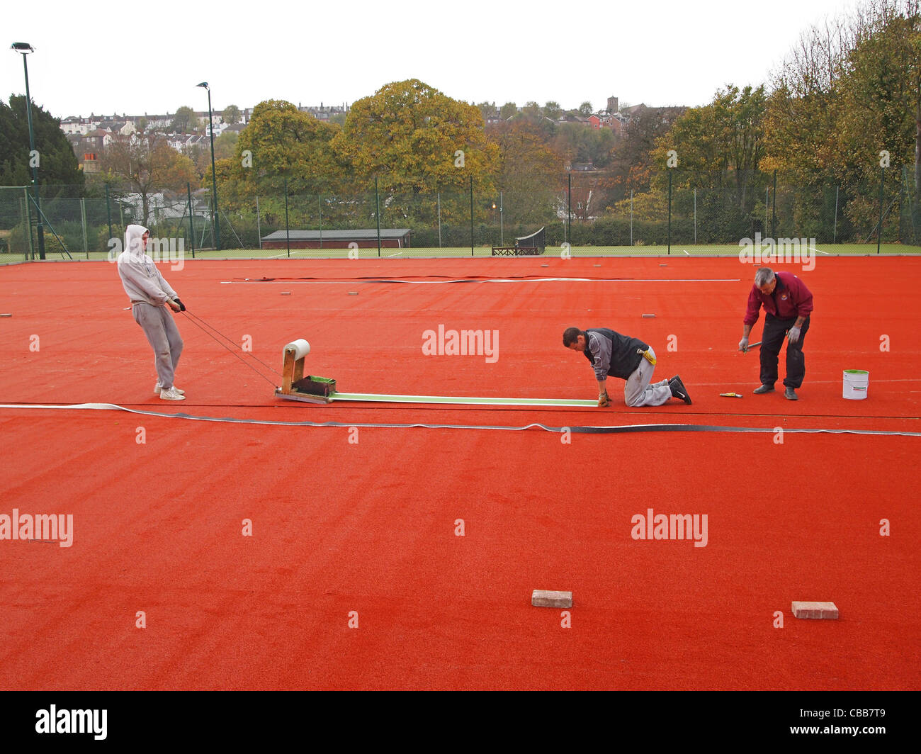 Construction of synthetic clay tennis courts - cutting in the white 'lines' into the stability base Stock Photo