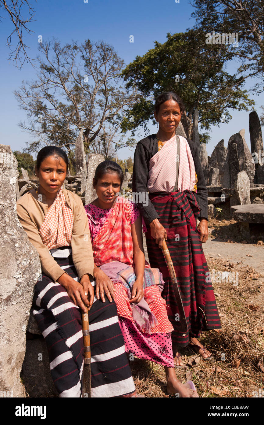 India, Meghalaya, Jaintia Hills, Nartiang Megaliths, three woman sweepers resting in paths between stone monoliths Stock Photo