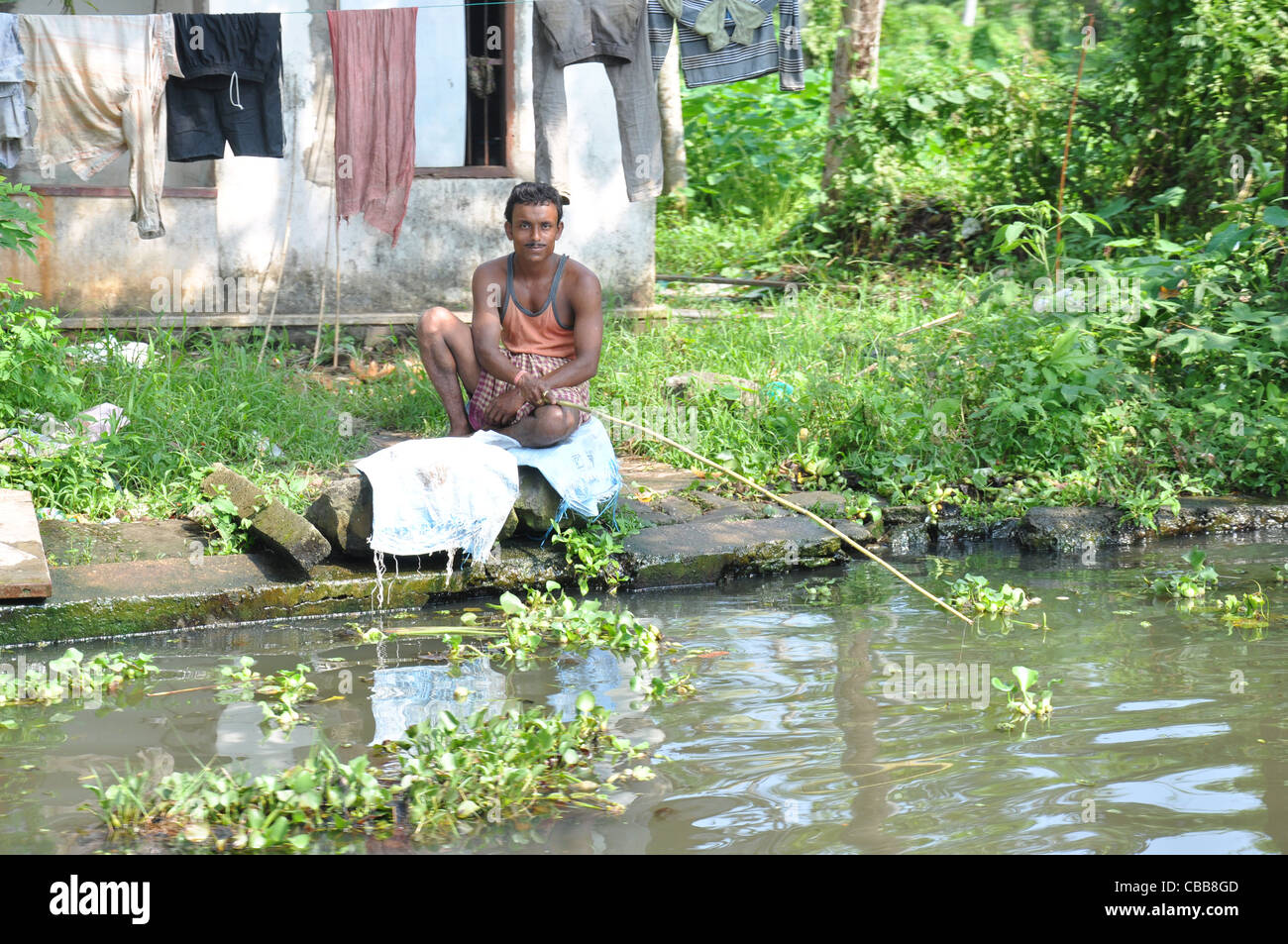 A man fishing  from the river alapuzha kerala in traditional dress Stock Photo