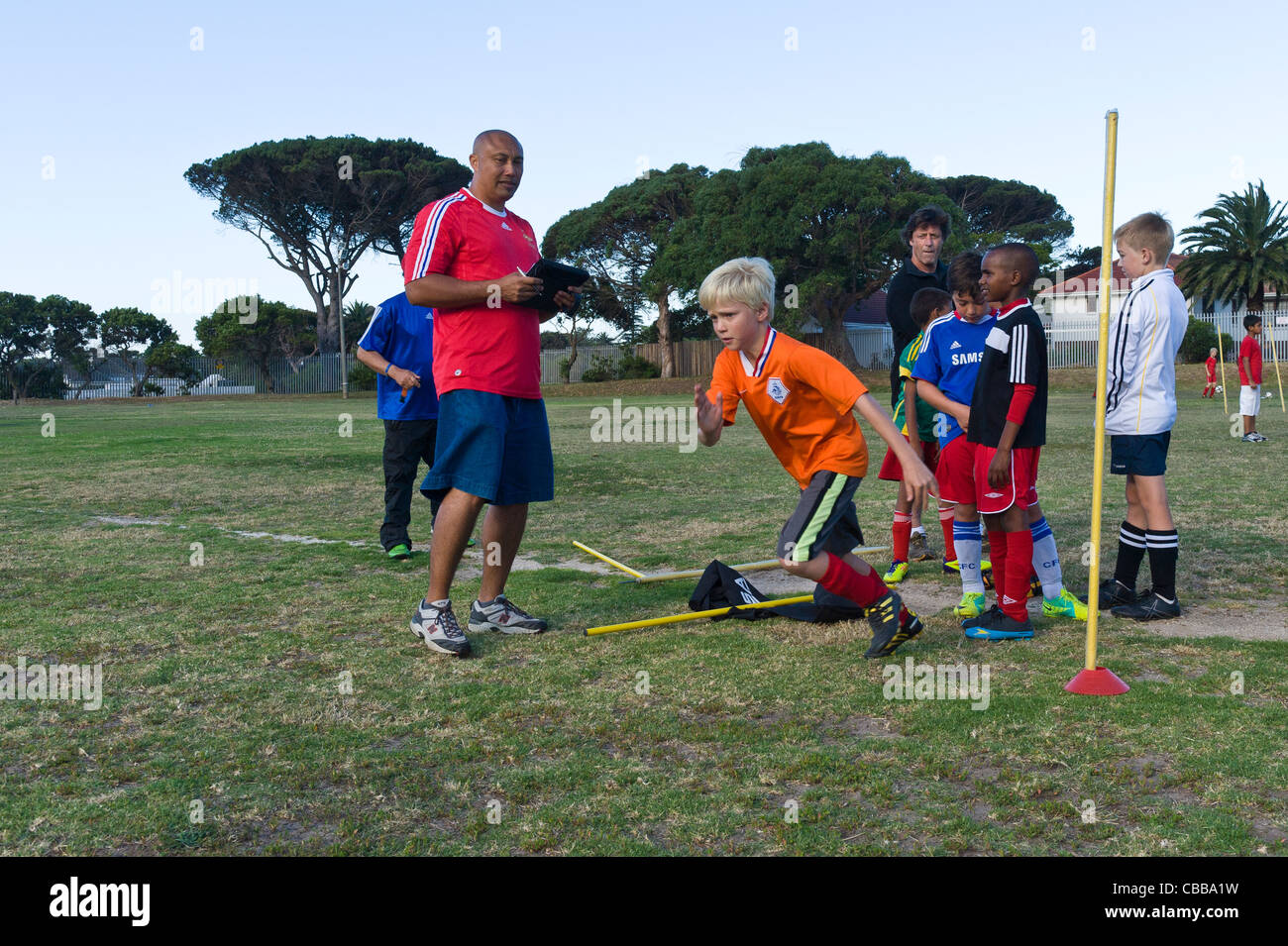 Football coach watching youth players exercising sprints Cape Town South Africa Stock Photo