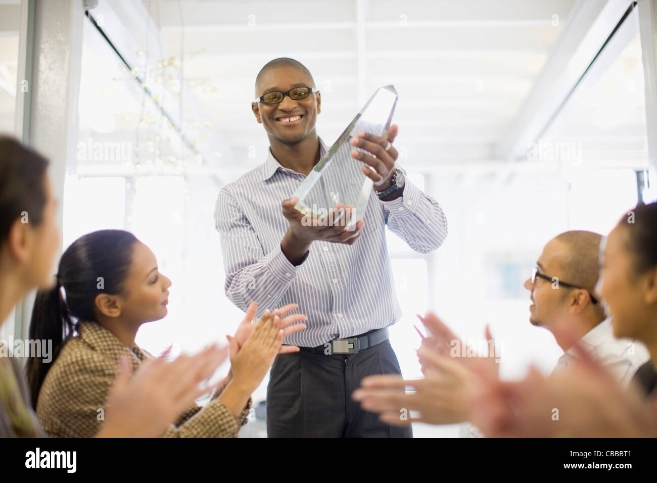 Businessman holding award in meeting Stock Photo