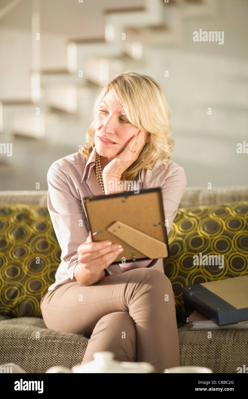 Older woman holding framed photo Stock Photo