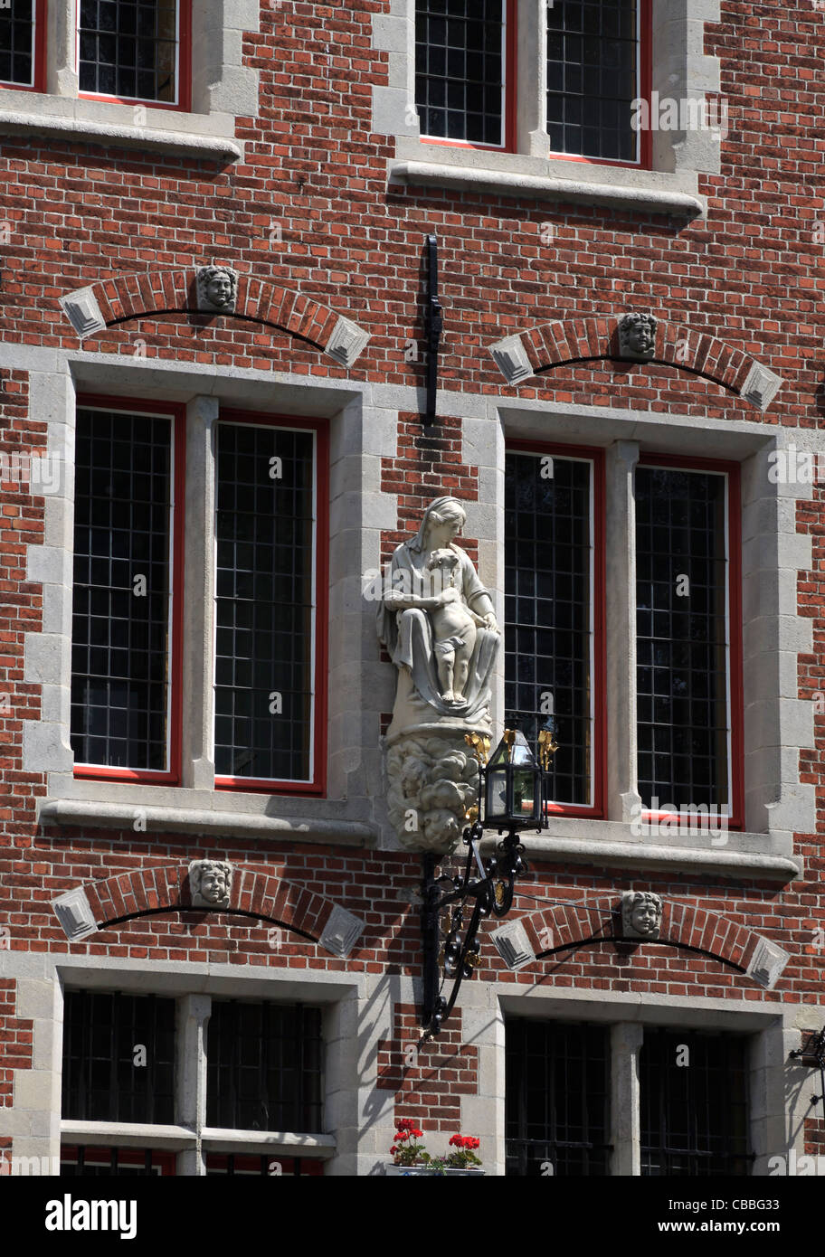 Statue of Madonna and Child on the side of a building in Wijngaardplein, Bruges Stock Photo