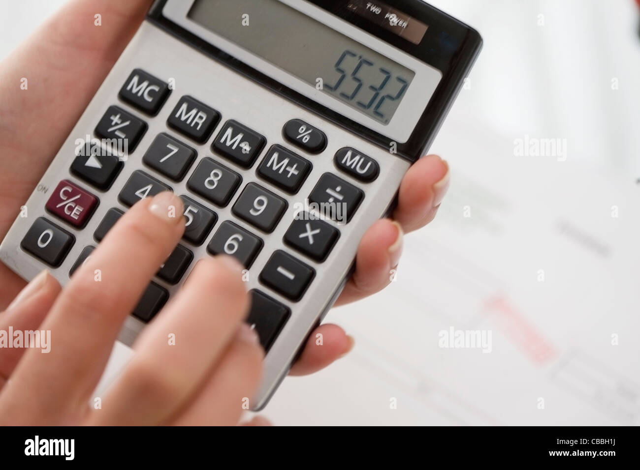 Close up of woman using calculator Stock Photo