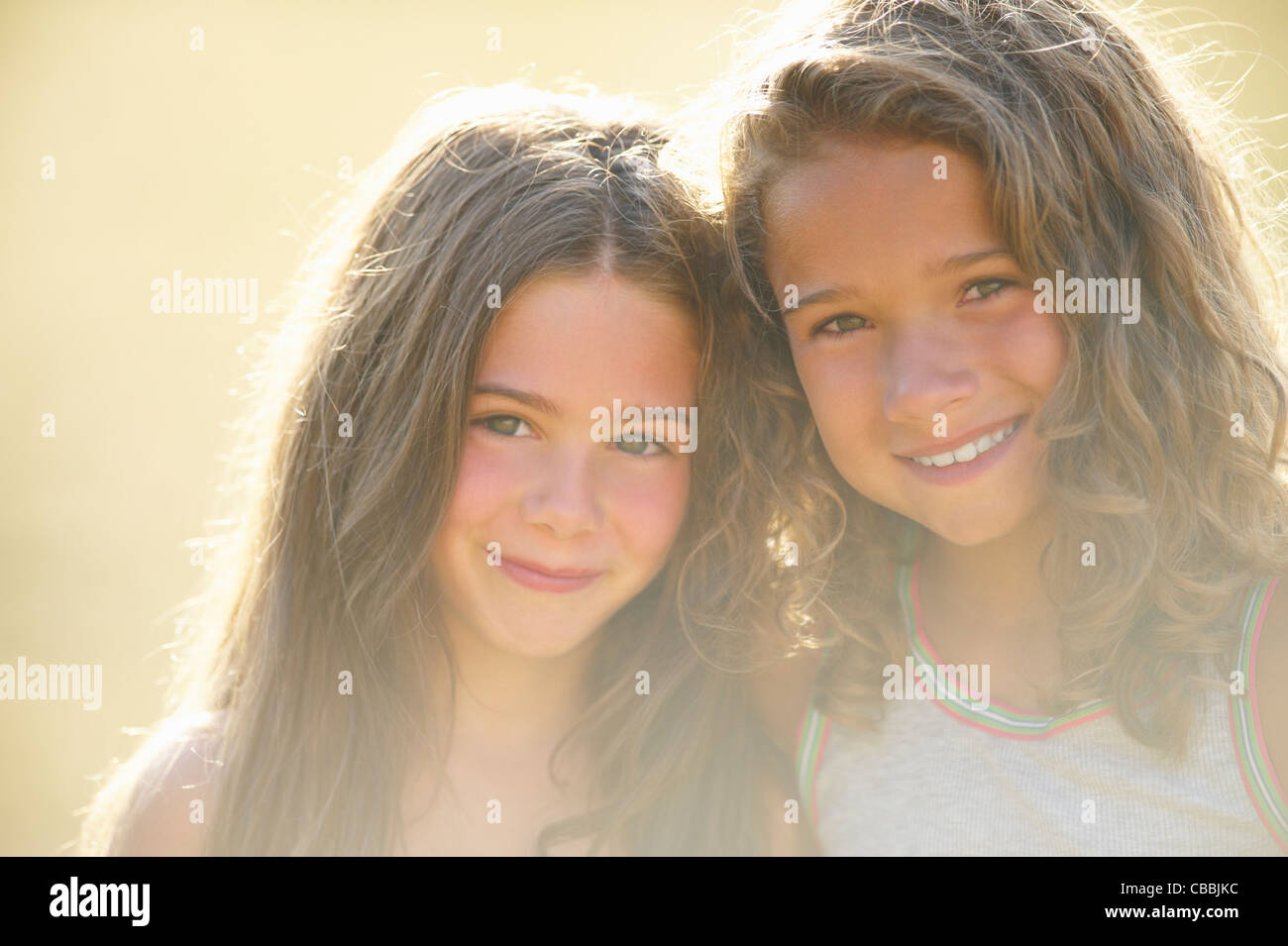 Smiling sisters hugging outdoors Stock Photo