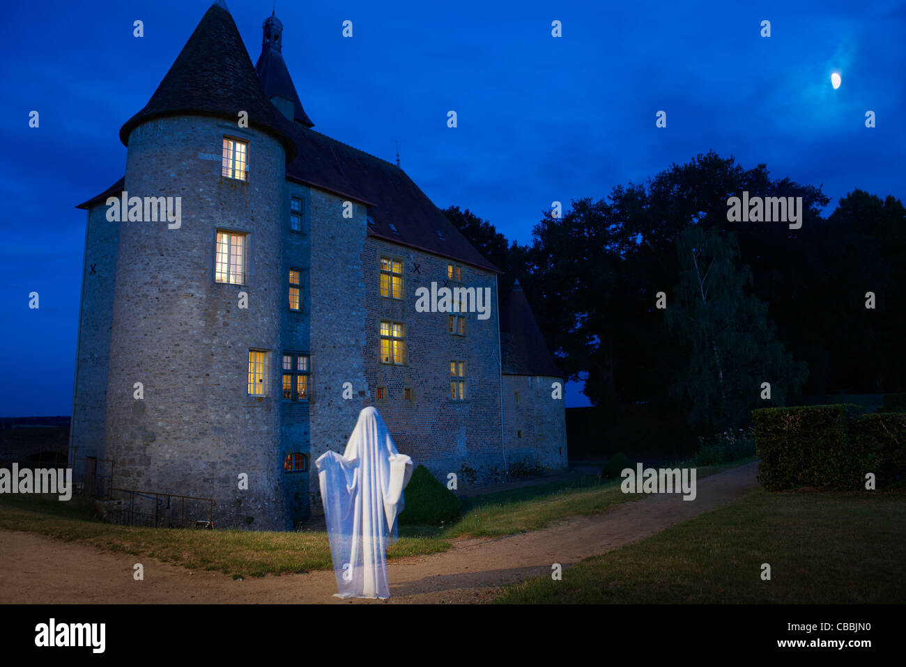 Ghost floating outside stone house Stock Photo