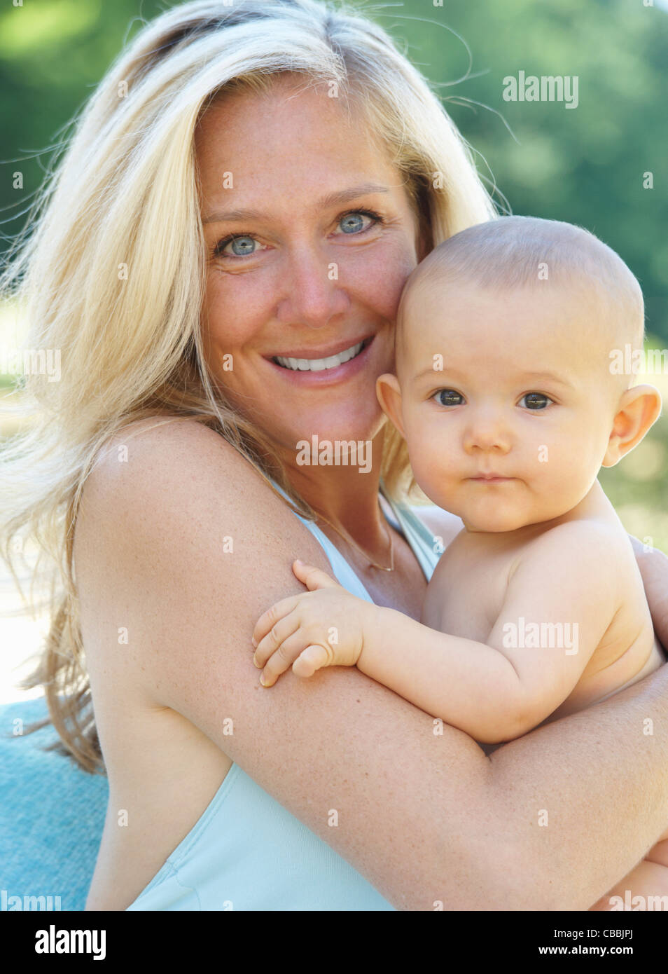 Smiling mother holding baby outdoors Stock Photo