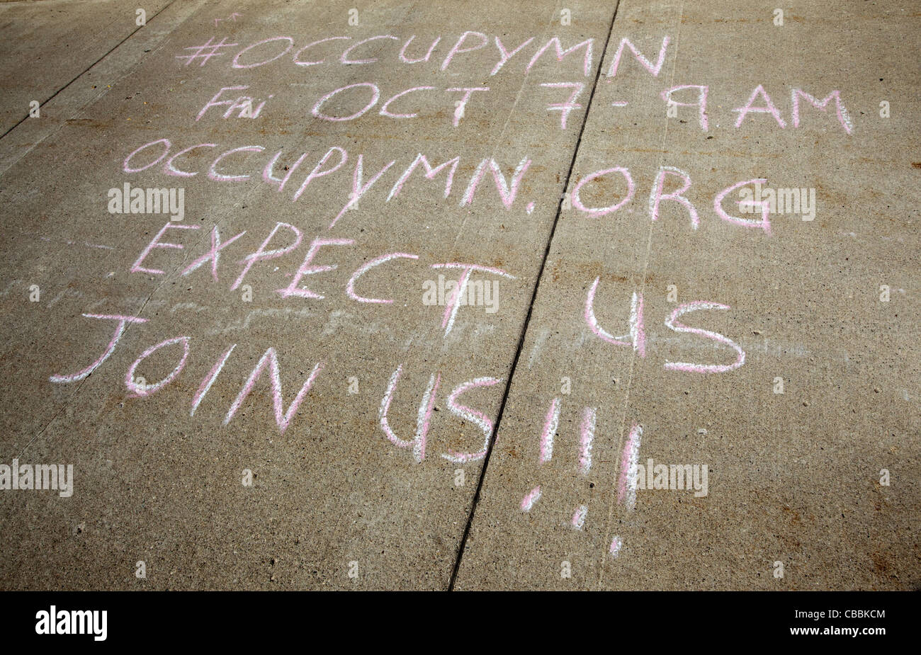 An announcement written with chalk on a cement sidewalk for OccupyMN in Minneapolis, Minnesota – October 2011 Stock Photo