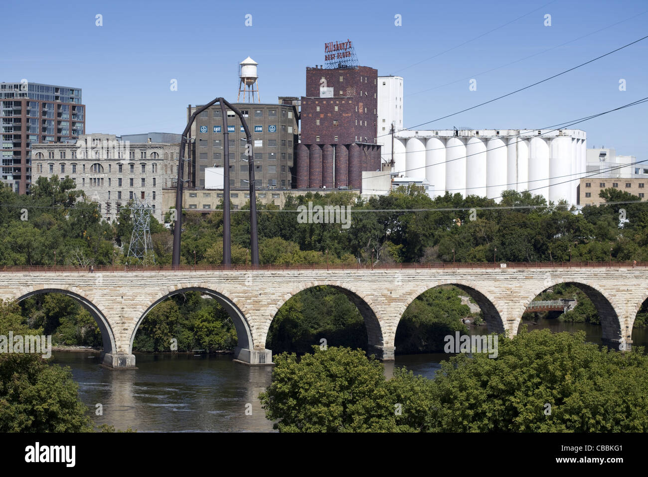 The Stone Arch Bridge and Pillsbury Milling complex along the Mississippi River in Minneapolis, Minnesota Stock Photo