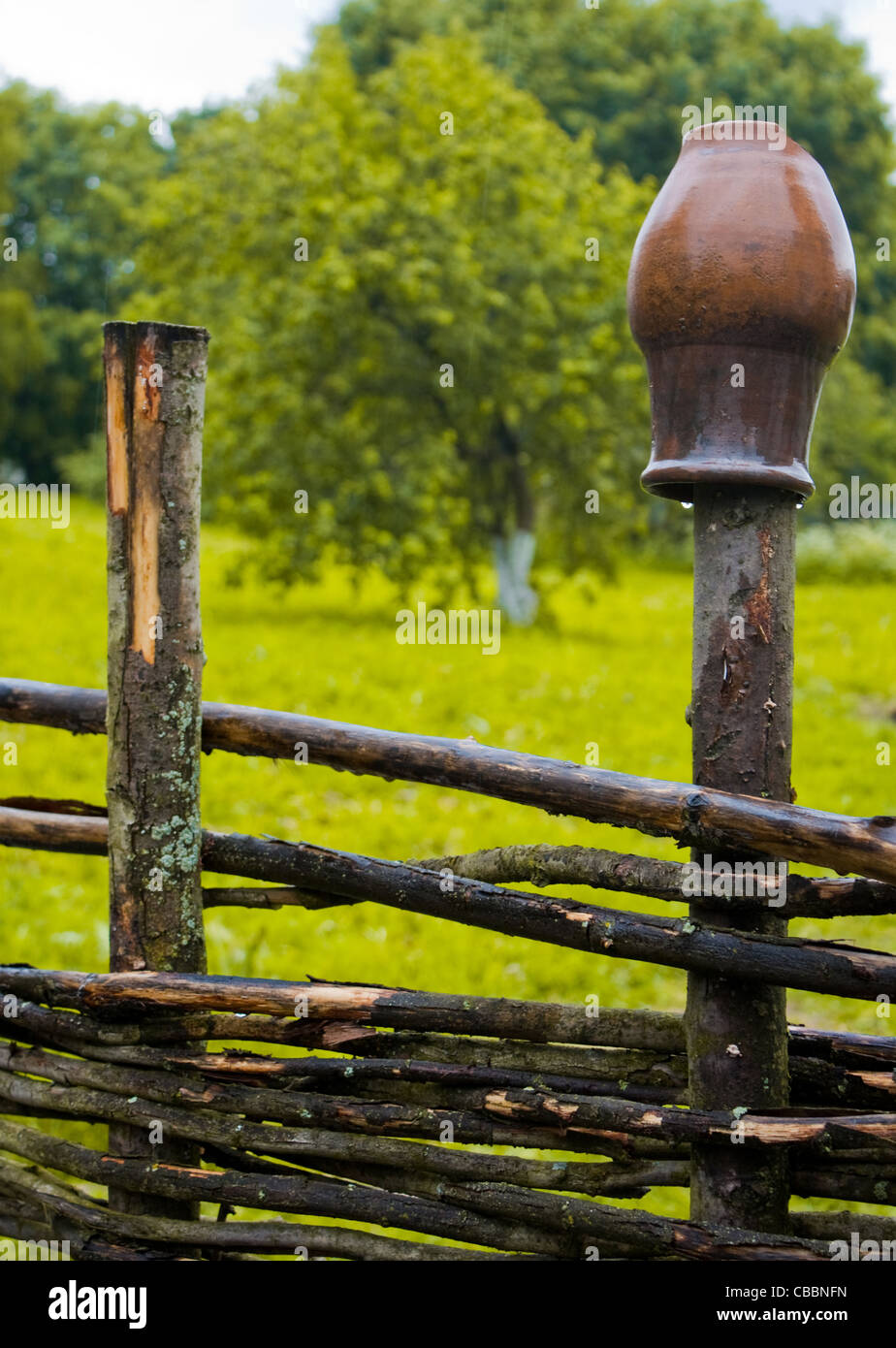 pot on wooden farm fence with grass and tree in background Stock Photo -  Alamy