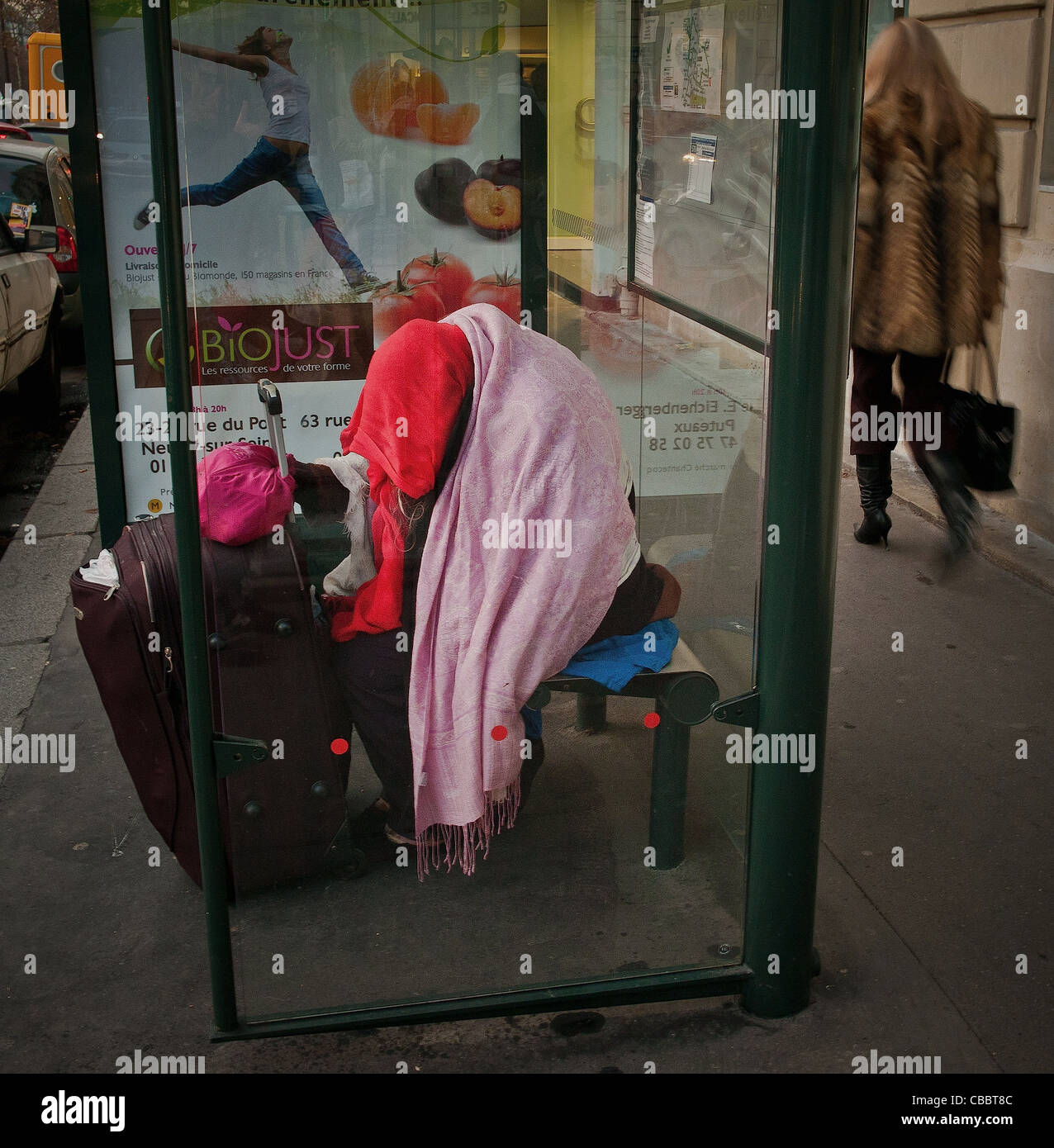 urban misery, Modern times. Bus shelter in Neuilly sur Seine, a sleeping homeless the day it's cold night and often fear Stock Photo