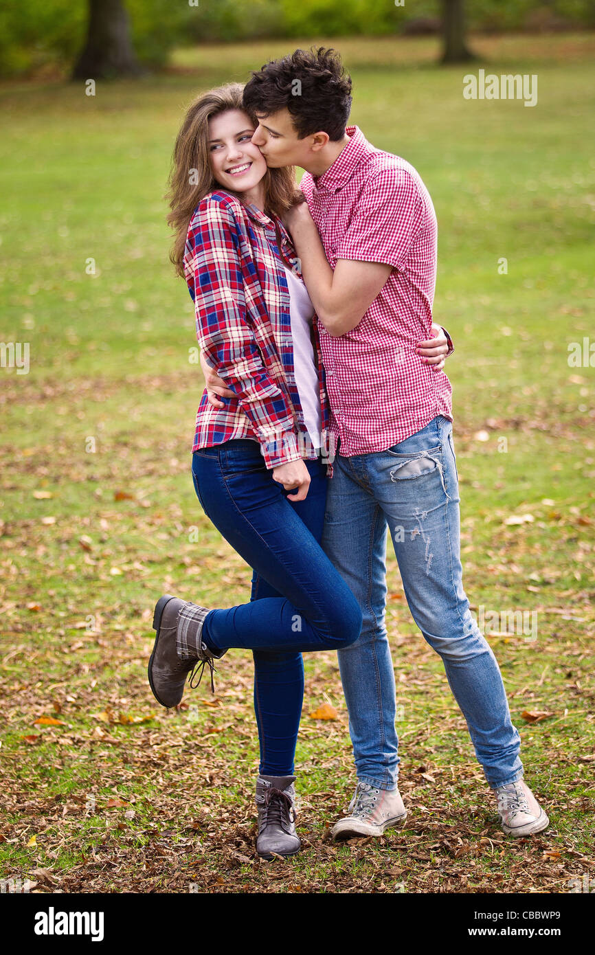 Teenage couple kissing in park Stock Photo