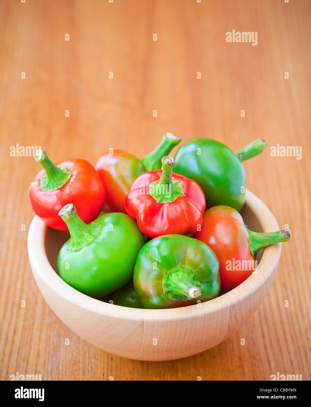 Hot cherry peppers in a bowl on a table Stock Photo
