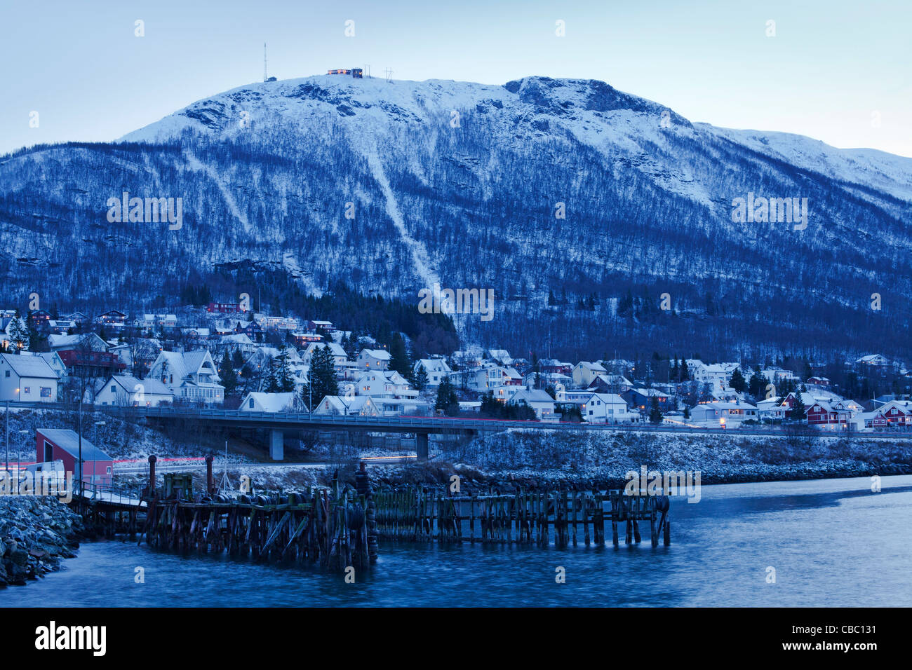Storsteinen, overlooking the harbour area of Tromsdalen, during the winter twilight. Stock Photo