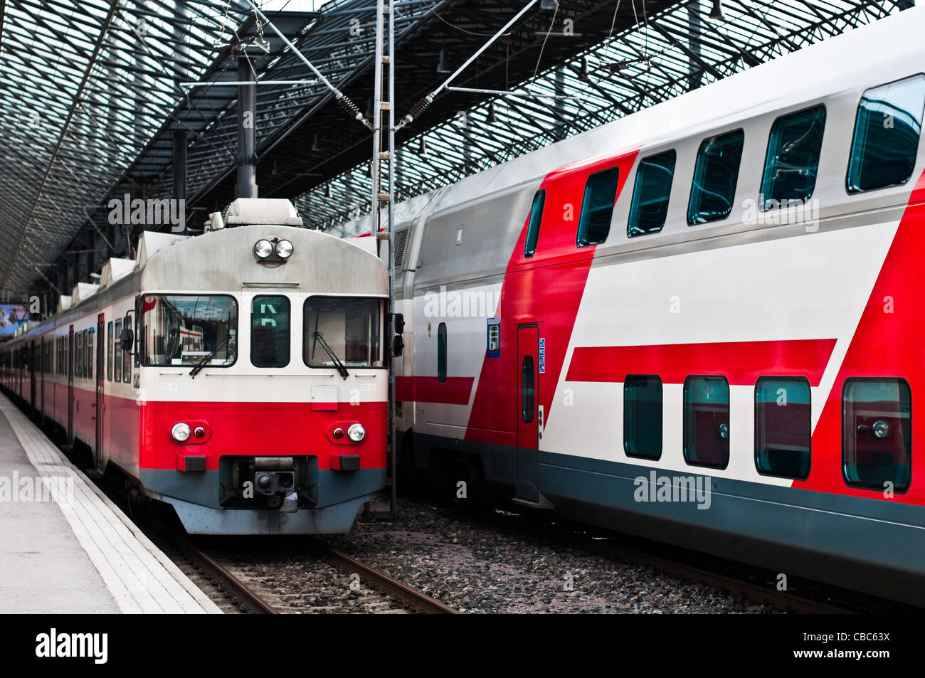 two trains in white and red color, one new and one old model at train station in Helsinki, Finland Stock Photo