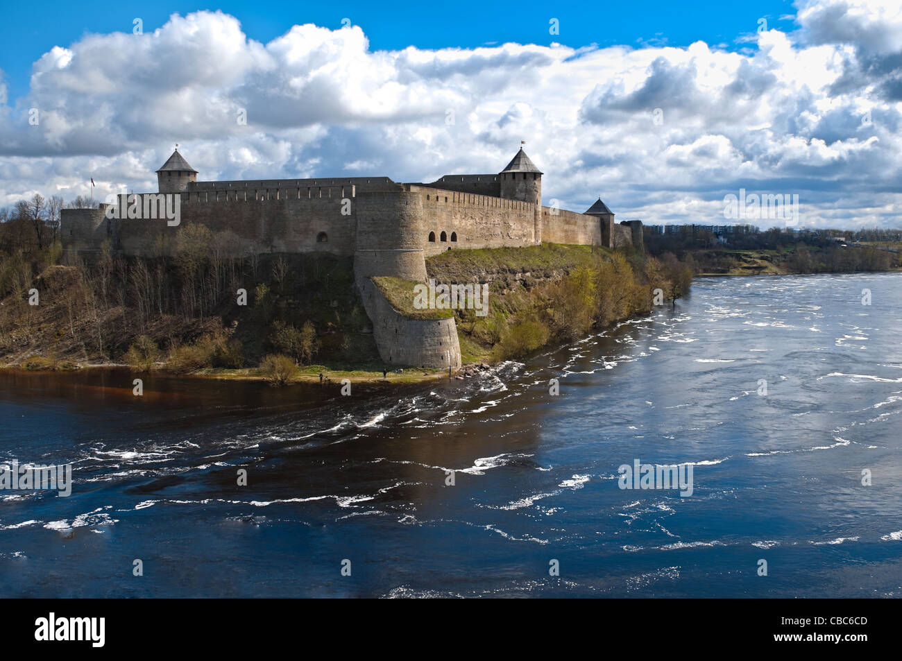 russian fortress of Ivangorod with river in foreground and blue cloudy sky in background Stock Photo