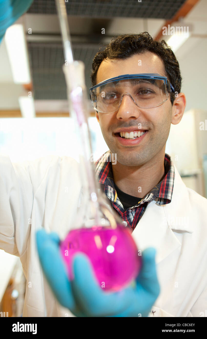 Scientist examining liquid in beaker Stock Photo Alamy