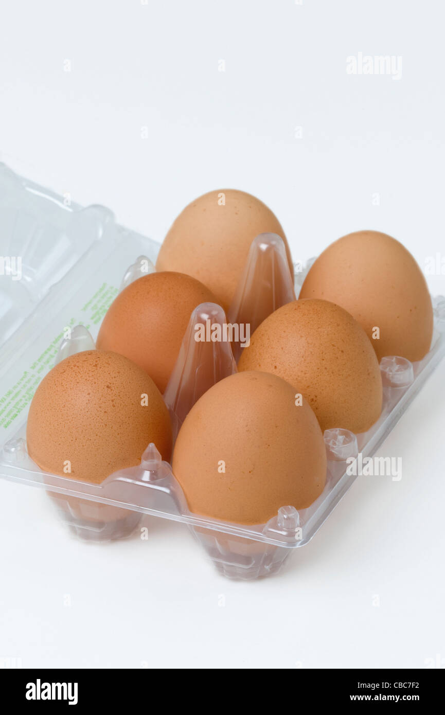 six or half a dozen brown hens eggs in a transparent plastic egg tray