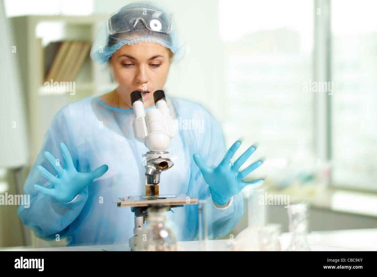 Surprised clinician looking in microscope in laboratory Stock Photo Alamy