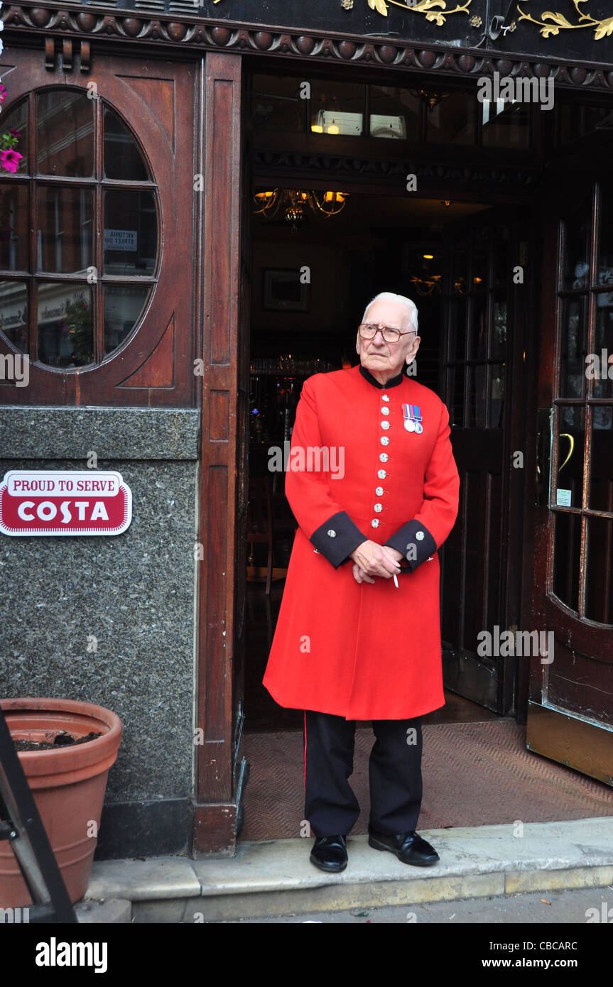 A Chelsea Pensioner steps outside The Albert Pub in Victoria St London UK Stock Photo