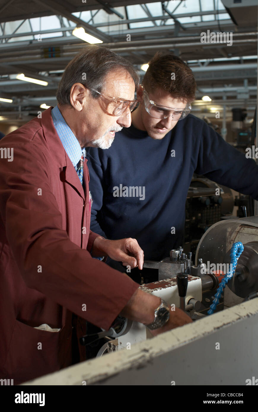 Teacher helping students in shop class Stock Photo Alamy