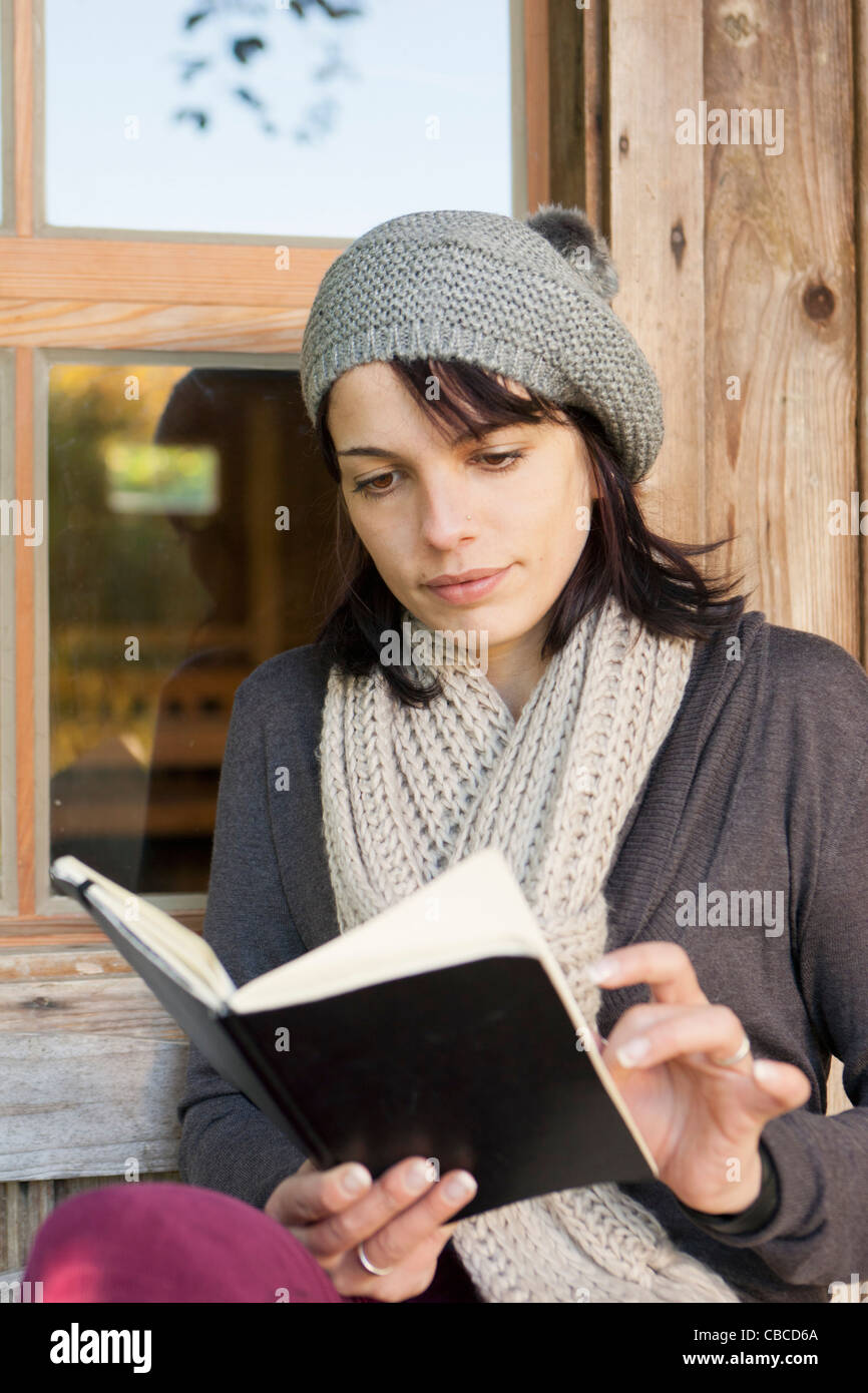 Woman reading book on porch Stock Photo - Alamy