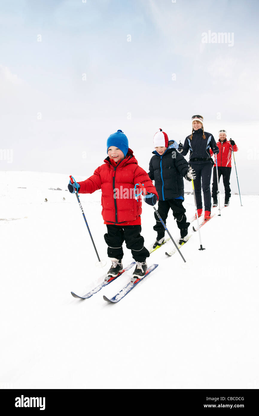 Family cross country skiing in snow Stock Photo