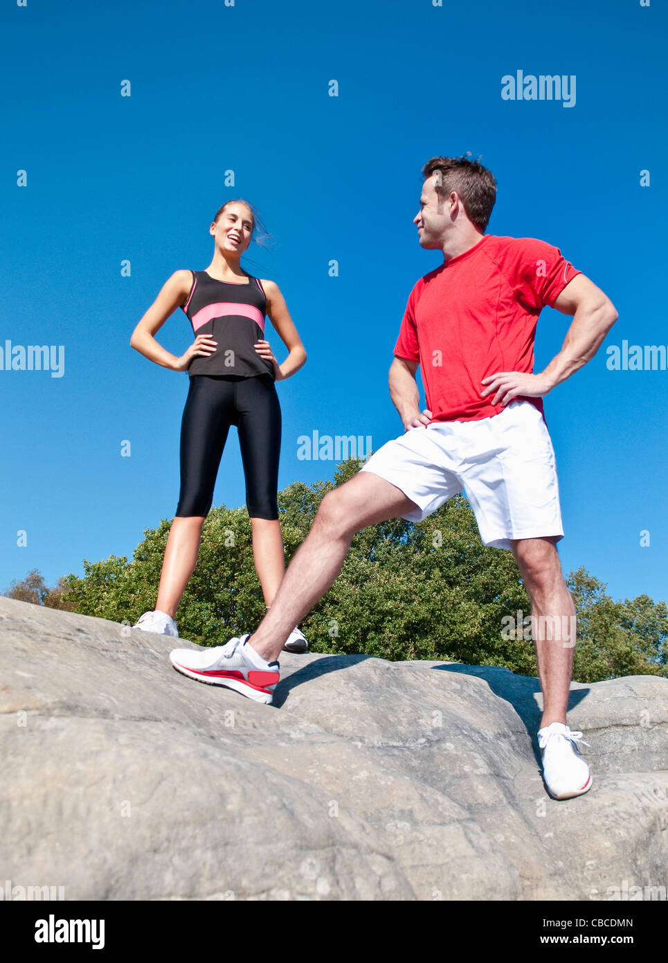 Rock climbers standing on boulder Stock Photo
