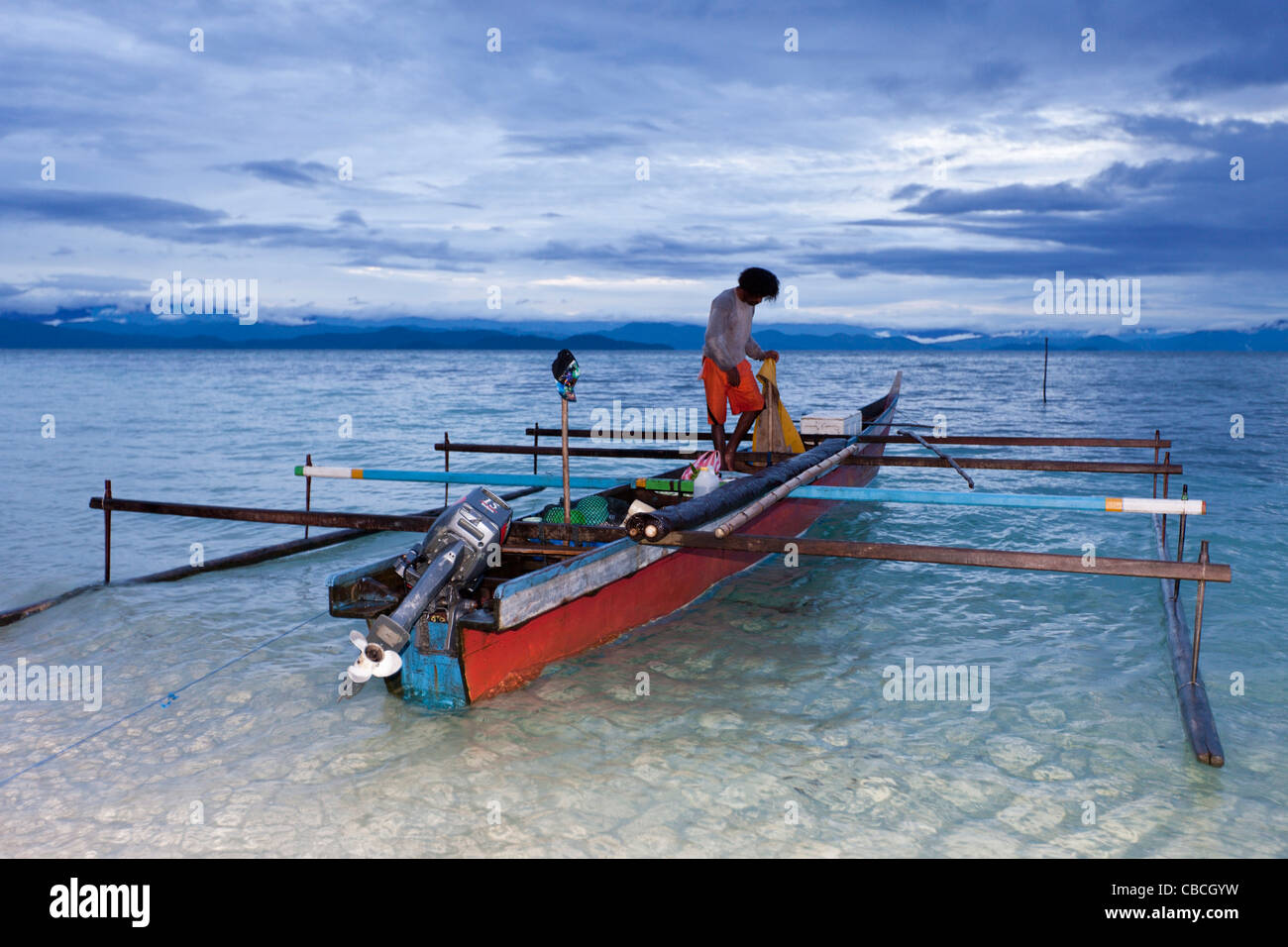 Fisherman on Outrigger Boat, Cenderawasih Bay, West Papua, Indonesia Stock Photo