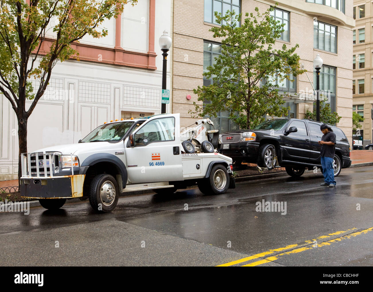 An SUV hitched to a wheel-lift tow truck - USA Stock Photo