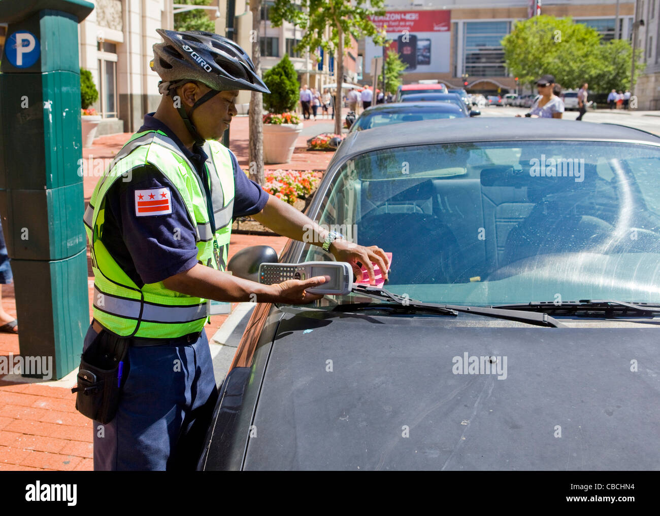 A parking enforcement places a ticket on car - Washington, DC USA Stock Photo